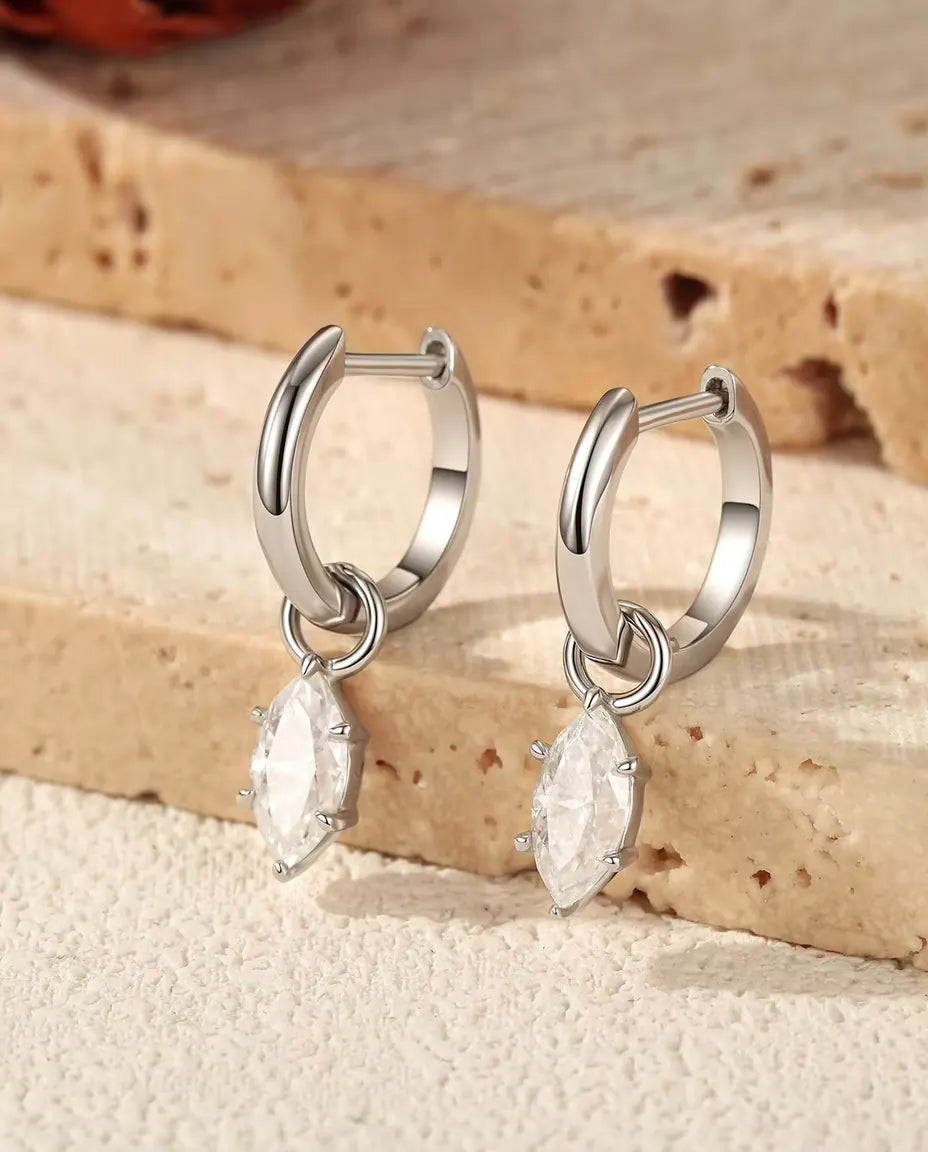 Pendientes Aro Huggie con Colgante de Moissanita Marquesa en Plata 925 - el par sobre unos escalones de travertino