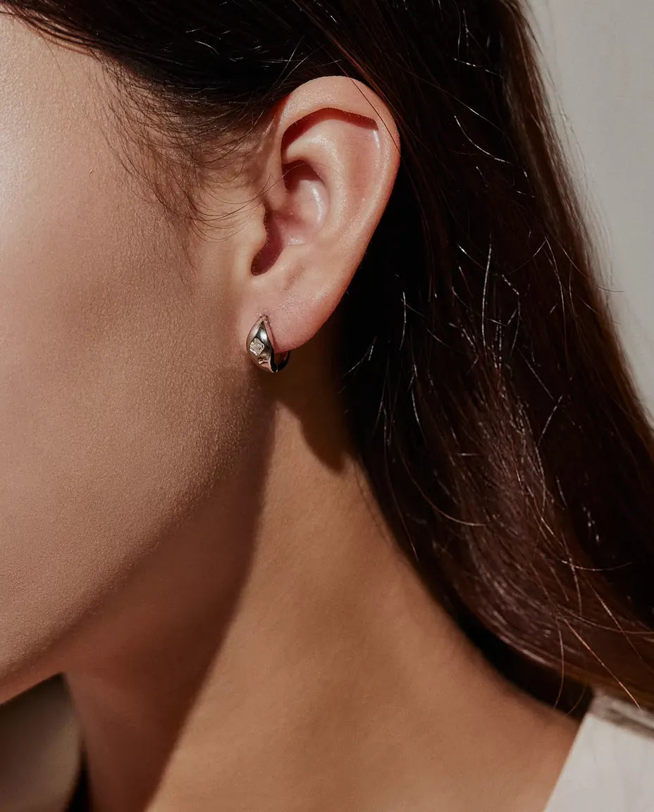 Pendientes de Aro Huggie de Moissanita Talla Asscher en Plata 925 - llevados en la oreja de una modelo, de perfil