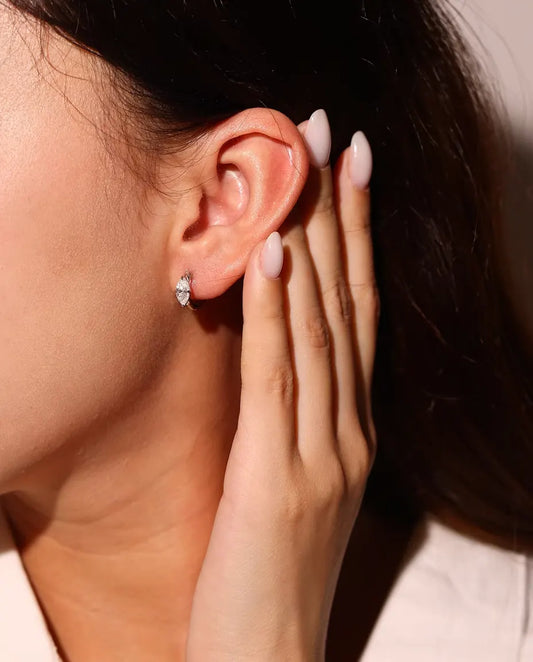 Pendientes de Aro de Moissanita en Plata 925 - llevados en la oreja de una modelo, con la mano cerca de la cara