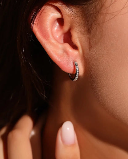 Pendientes de Aro de Moissanita en Plata 925 - llevados en la oreja de una modelo, con la mano cerca de la cara