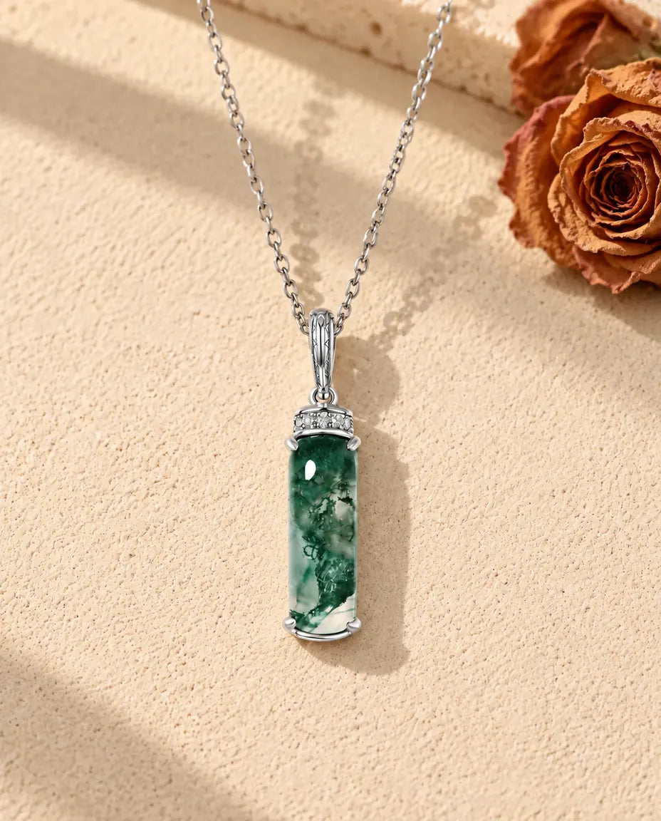 Collar de Ágata Musgosa Barra Larga en Plata 925 - sobre una superficie clara con textura junto a un bloque de travertino