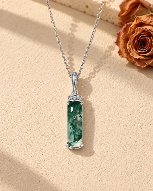 Collar de Ágata Musgosa Barra Larga en Plata 925 - sobre una superficie clara con textura junto a un bloque de travertino