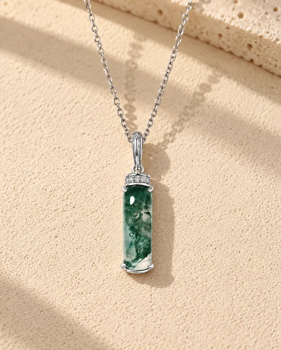 Collar de Ágata Musgosa Barra Larga en Plata 925 - sobre una superficie clara con textura junto a un bloque de travertino