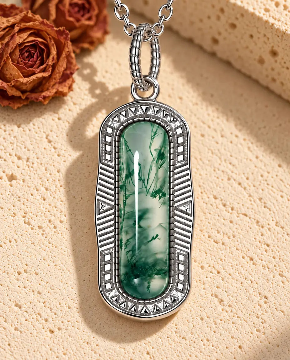 Collar de Ágata Musgosa Cápsula en Plata 925 - sobre una superficie clara con textura junto a un bloque de travertino