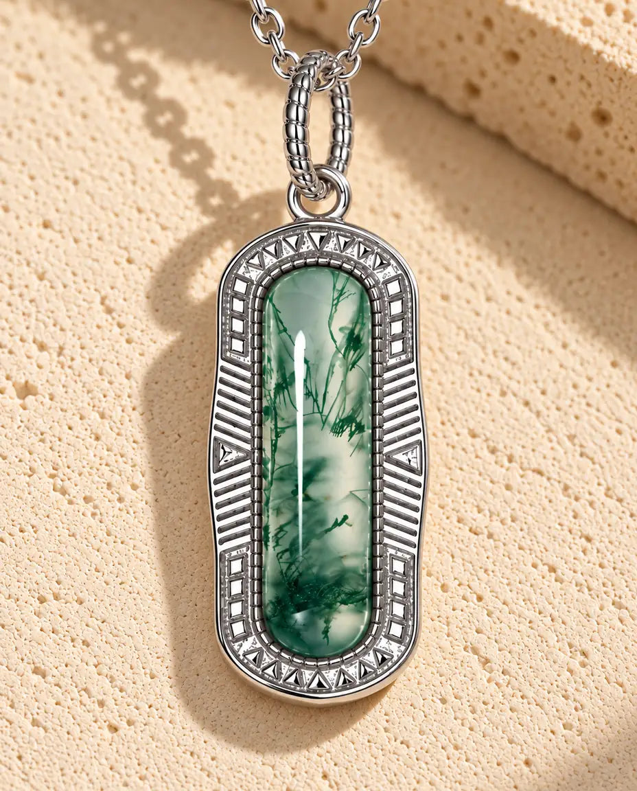 Collar de Ágata Musgosa Cápsula en Plata 925 - sobre una superficie clara con textura junto a un bloque de travertino