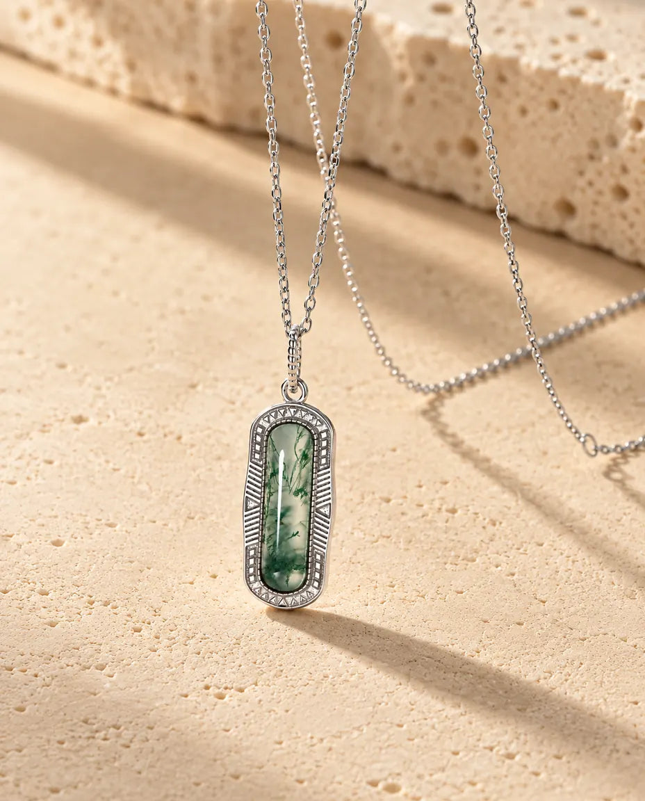 Collar de Ágata Musgosa Cápsula en Plata 925 - visto en ángulo sobre una superficie clara con textura