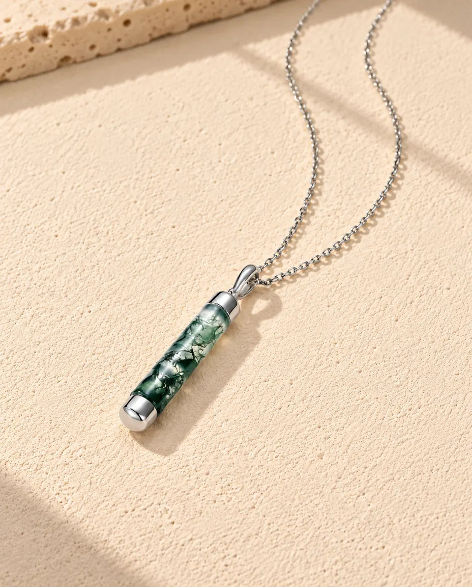 Collar de Ágata Musgosa Cilindro Largo en Plata 925 - visto en ángulo sobre una superficie clara con textura