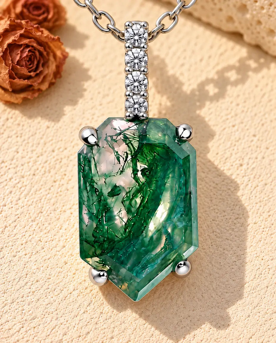 Collar de Ágata Musgosa con Colgante Escudo en Plata 925 - sobre una superficie clara con textura junto a un bloque de travertino