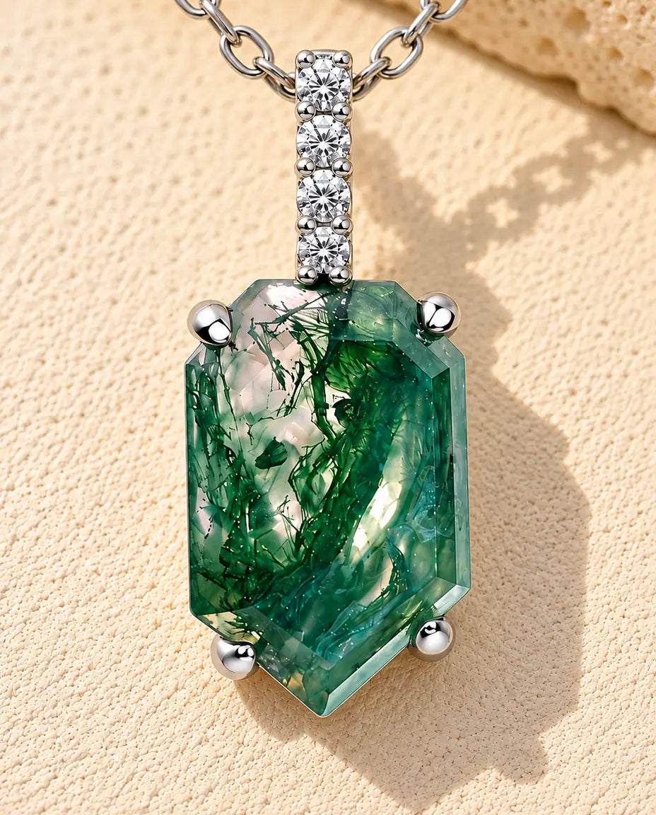 Collar de Ágata Musgosa con Colgante Escudo en Plata 925 - sobre una superficie clara con textura junto a un bloque de travertino