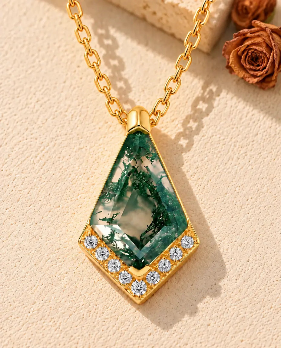 Collar de Ágata Musgosa en Plata 925 Chapada en Oro - sobre una superficie clara con textura junto a un bloque de travertino