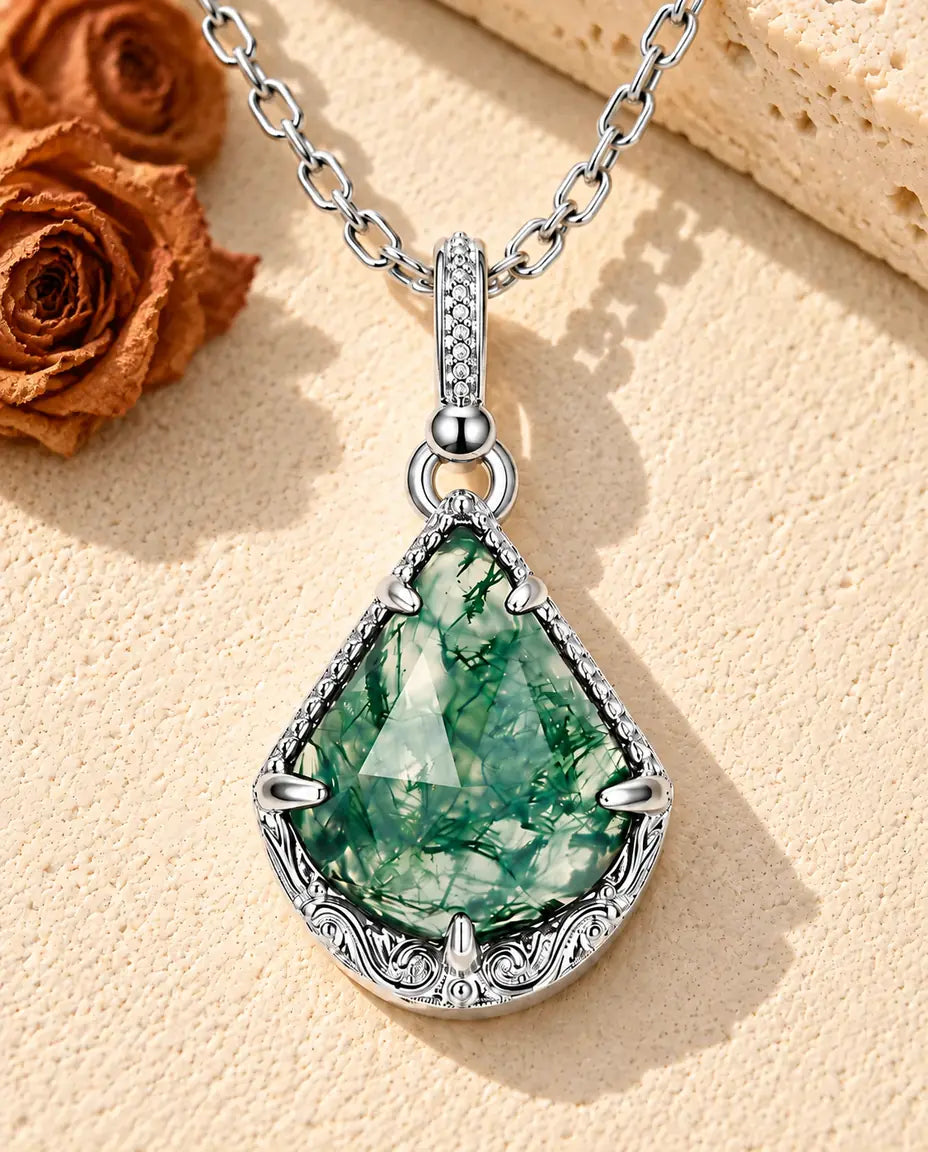 Collar de Ágata Musgosa Escudo en Plata 925 - sobre una superficie clara con textura junto a un bloque de travertino