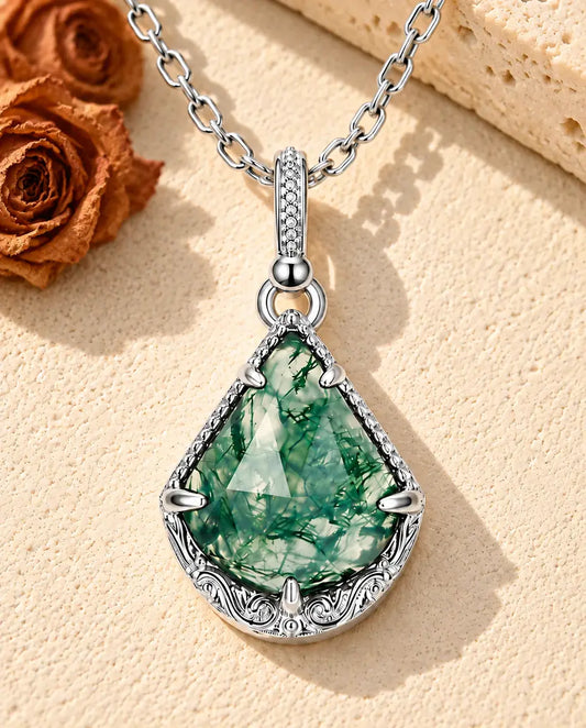 Collar de Ágata Musgosa Escudo en Plata 925 - sobre una superficie clara con textura junto a un bloque de travertino