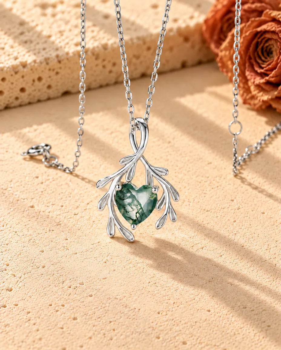 Collar de Ágata Musgosa Corazón y Ramas en Plata 925 - visto en ángulo sobre una superficie clara con textura