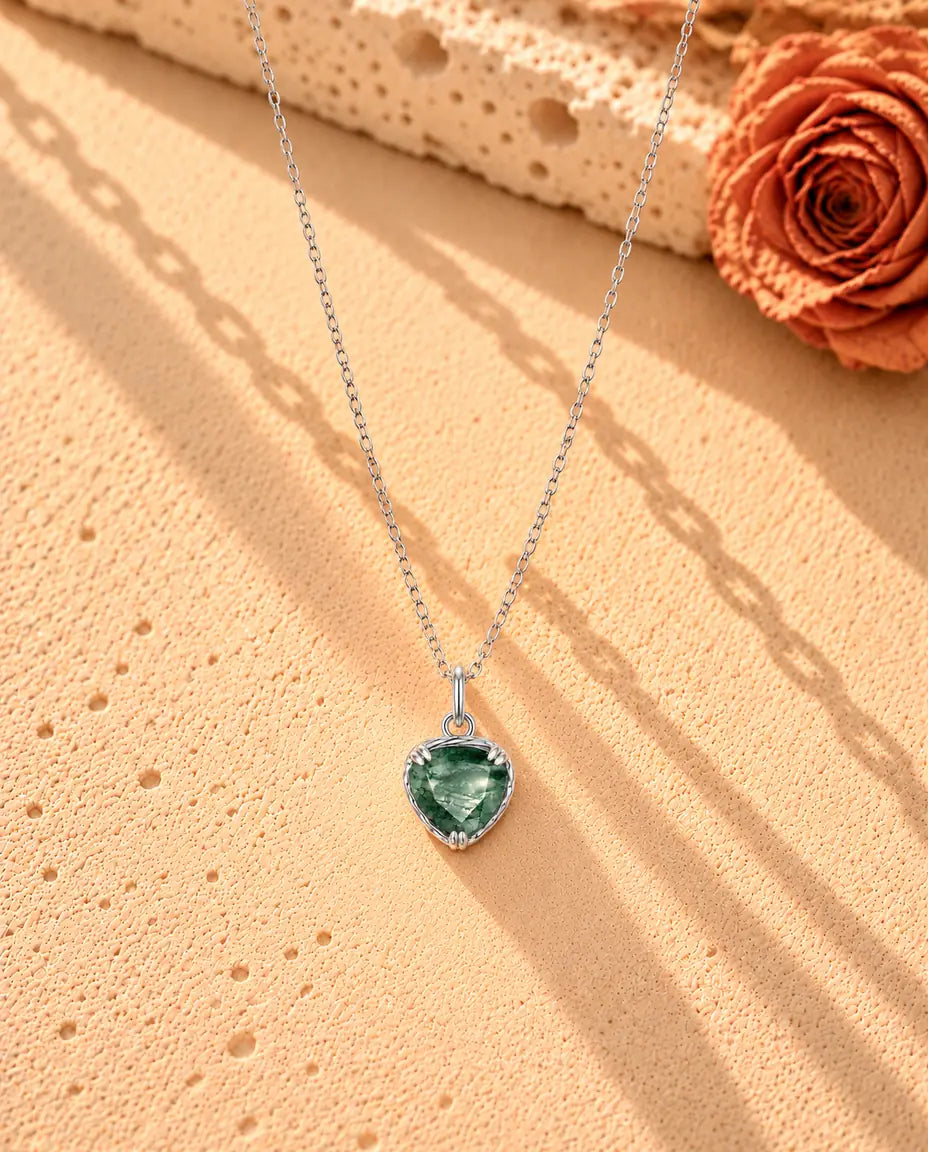 Collar Colgante Corazón de Ágata Musgosa en Plata 925 - el collar completo extendido en una larga V sobre una superficie clara con textura