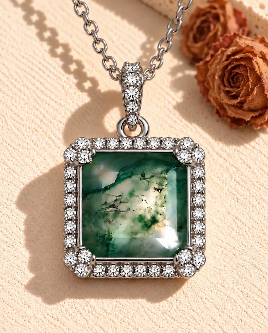 Collar de Ágata Musgosa Cuadrada en Plata 925 - sobre una superficie clara con textura junto a un bloque de travertino