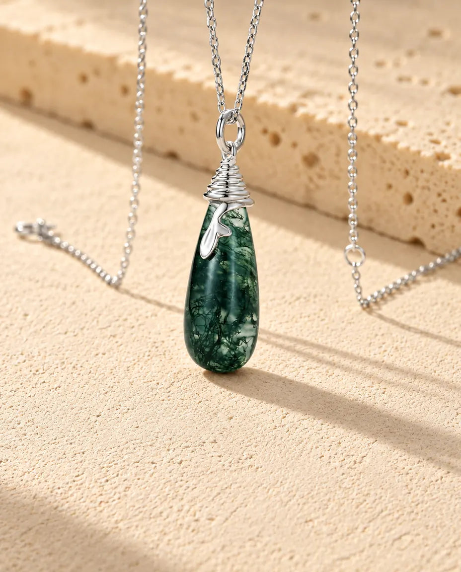 Collar de Ágata Musgosa en Forma de Gota en Plata 925 - visto en ángulo sobre una superficie clara con textura