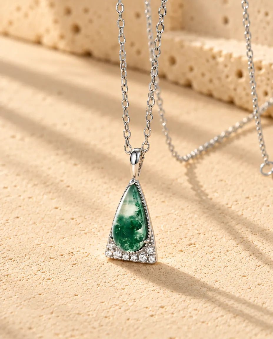 Collar de Ágata Musgosa Triángulo en Plata 925 - visto en ángulo sobre una superficie clara con textura