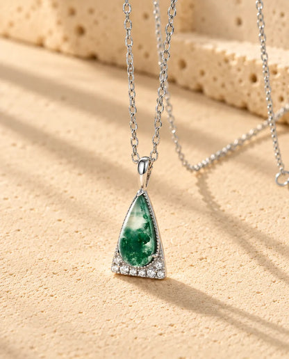 Collar de Ágata Musgosa Triángulo en Plata 925 - visto en ángulo sobre una superficie clara con textura