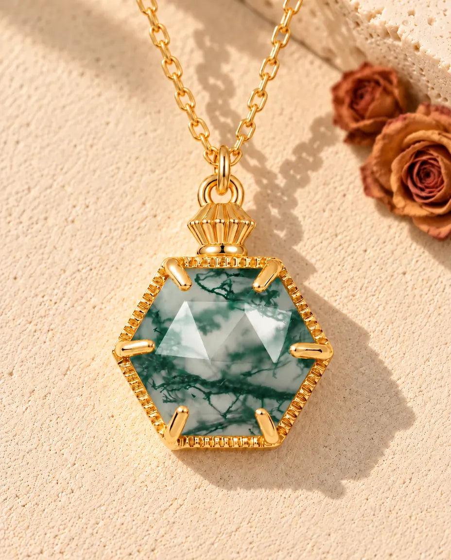 Collar de Ágata Musgosa Hexagonal en Plata 925 Chapada en Oro - sobre una superficie clara con textura junto a un bloque de travertino