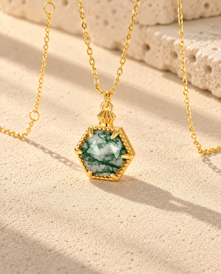 Collar de Ágata Musgosa Hexagonal en Plata 925 Chapada en Oro - visto en ángulo sobre una superficie clara con textura