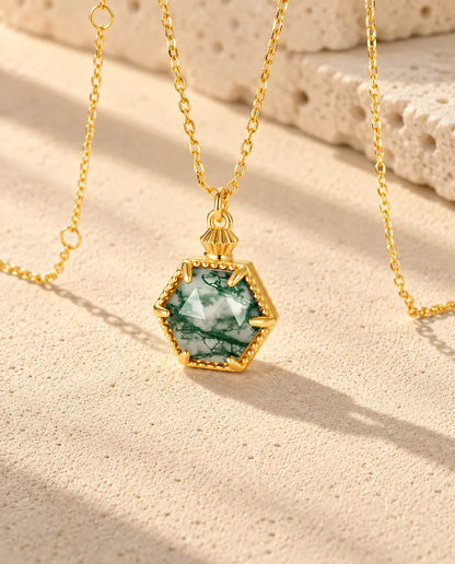 Collar de Ágata Musgosa Hexagonal en Plata 925 Chapada en Oro - visto en ángulo sobre una superficie clara con textura