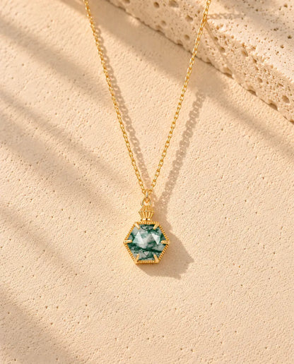 Collar de Ágata Musgosa Hexagonal en Plata 925 Chapada en Oro - el collar completo extendido en una larga V sobre una superficie clara con textura