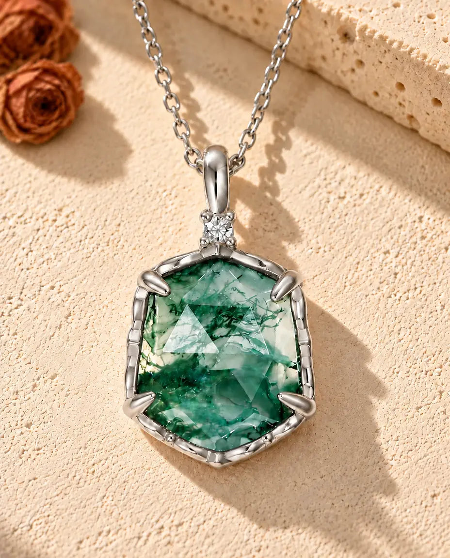 Collar de Ágata Musgosa Hexagonal en Plata 925 - sobre una superficie clara con textura junto a un bloque de travertino