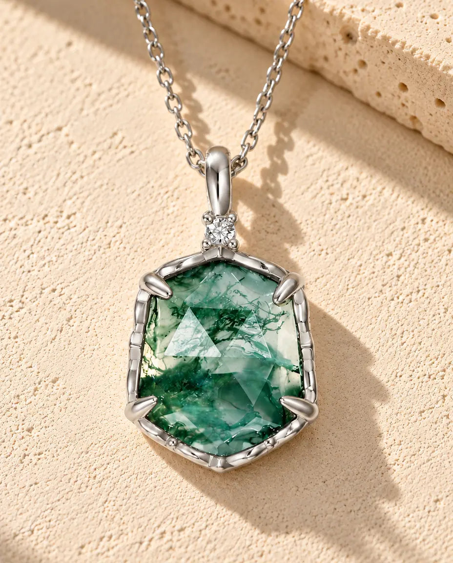 Collar de Ágata Musgosa Hexagonal en Plata 925 - sobre una superficie clara con textura junto a un bloque de travertino
