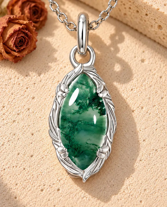 Collar de Ágata Musgosa Marquesa en Plata 925 - sobre una superficie clara con textura junto a un bloque de travertino