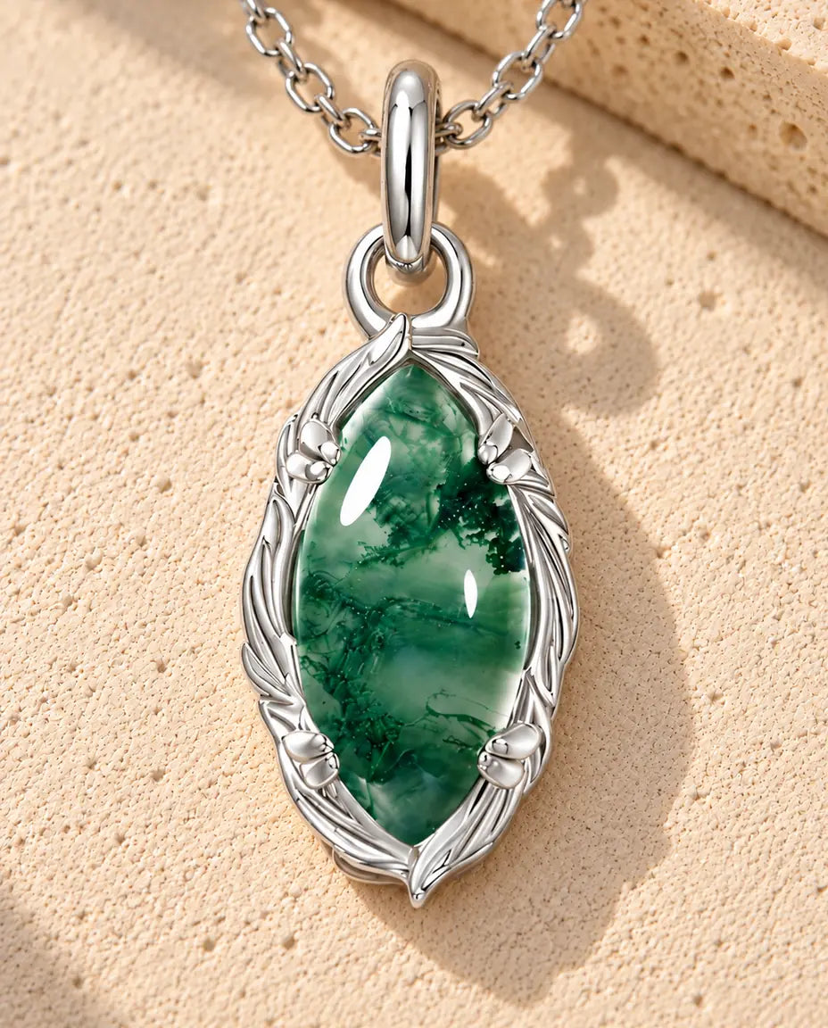 Collar de Ágata Musgosa Marquesa en Plata 925 - sobre una superficie clara con textura junto a un bloque de travertino