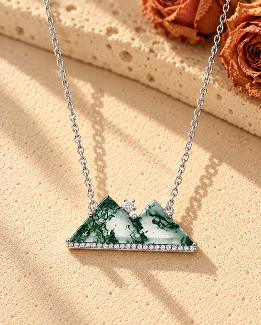 Collar Montaña de Ágata Musgosa en Plata 925 - sobre una superficie clara con textura junto a un bloque de travertino