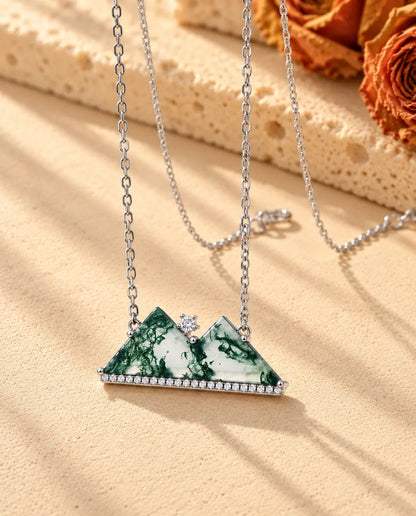 Collar Montaña de Ágata Musgosa en Plata 925 - visto en ángulo sobre una superficie clara con textura