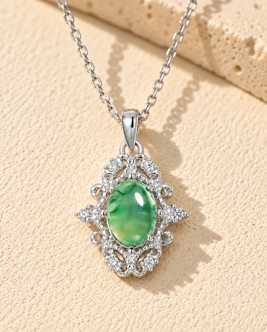 Collar de Ágata Musgosa Ovalada en Plata 925 - sobre una superficie clara con textura junto a un bloque de travertino