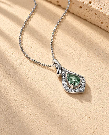 Collar de Ágata Musgosa en Forma de Pera en Plata 925 - visto en ángulo sobre una superficie clara con textura