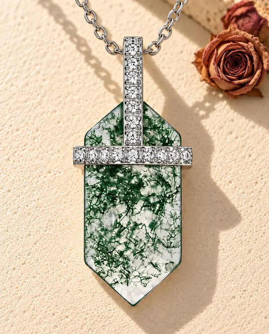 Collar de Ágata Musgosa Hexagonal en Plata 925 - sobre una superficie clara con textura junto a un bloque de travertino