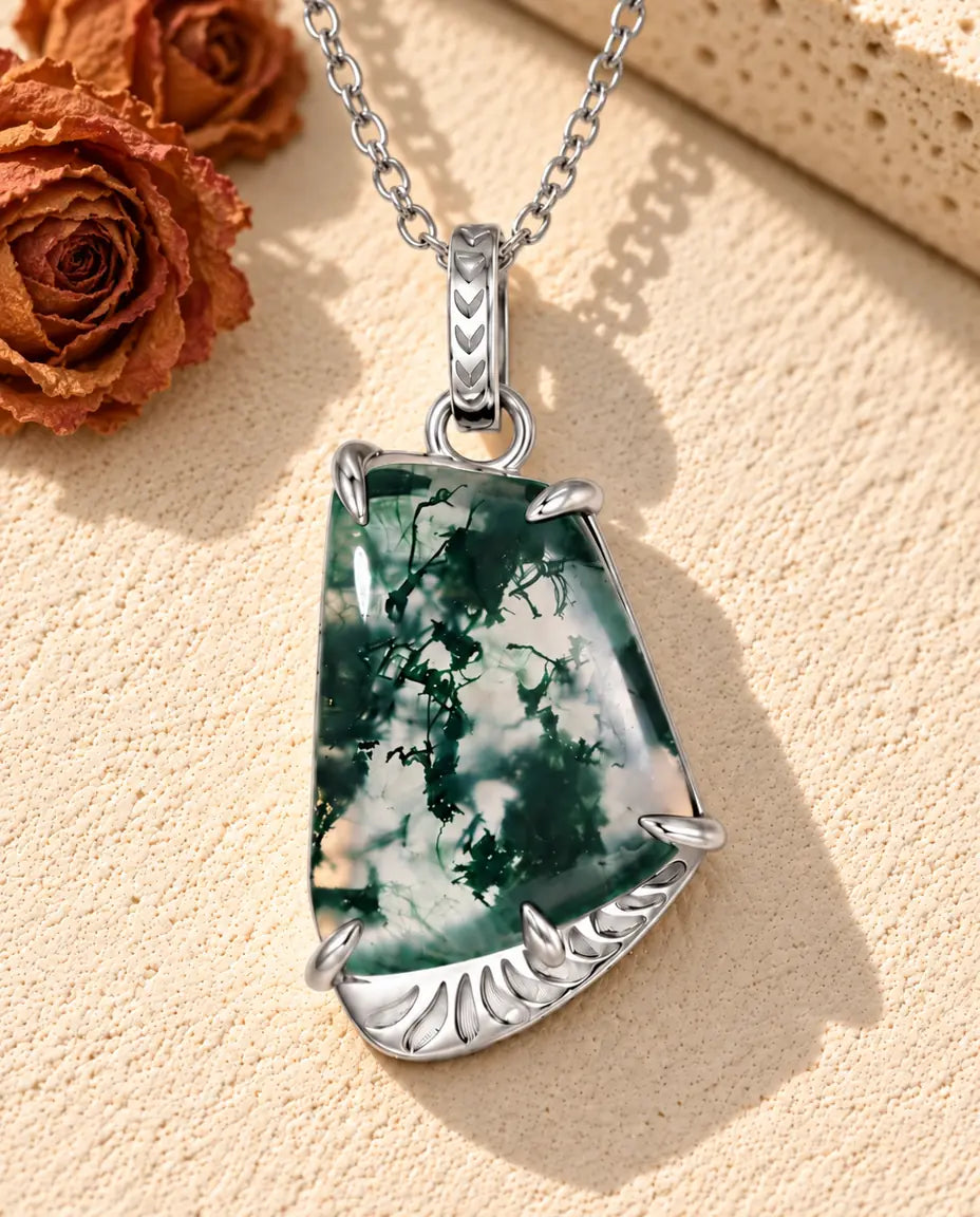 Collar de Ágata Musgosa Forma Libre en Plata 925 - sobre una superficie clara con textura junto a un bloque de travertino