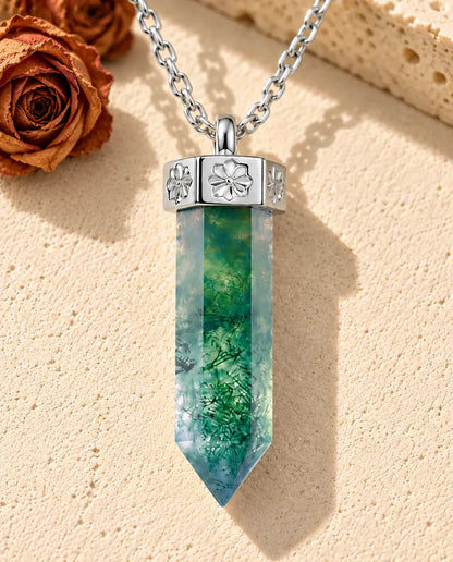 Collar de Ágata Musgosa Punta en Plata 925 - sobre una superficie clara con textura junto a un bloque de travertino