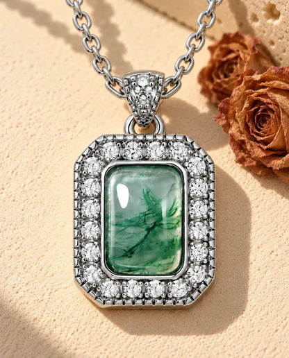 Collar de Ágata Musgosa Halo en Plata 925 - sobre una superficie clara con textura junto a un bloque de travertino