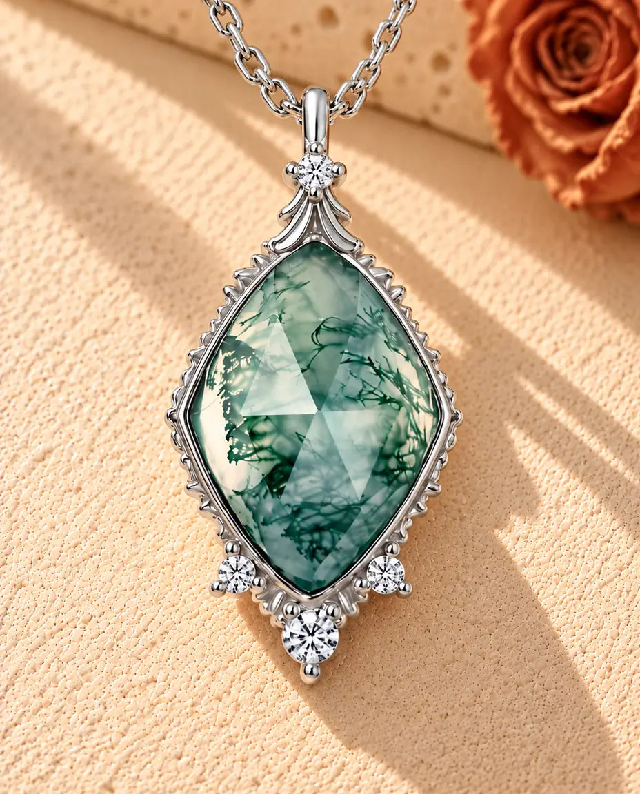 Collar de Ágata Musgosa en Rombo en Plata 925 - sobre una superficie clara con textura junto a un bloque de travertino