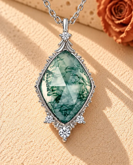 Collar de Ágata Musgosa en Rombo en Plata 925 - sobre una superficie clara con textura junto a un bloque de travertino
