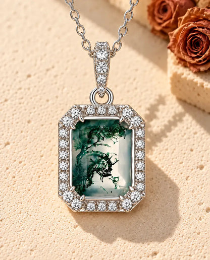 Collar de Ágata Musgosa Talla Esmeralda en Plata 925 - sobre una superficie clara con textura junto a un bloque de travertino