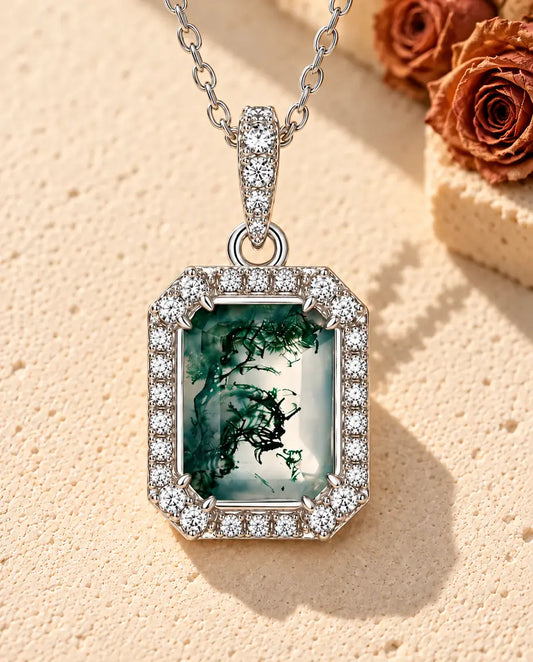 Collar de Ágata Musgosa Talla Esmeralda en Plata 925 - sobre una superficie clara con textura junto a un bloque de travertino