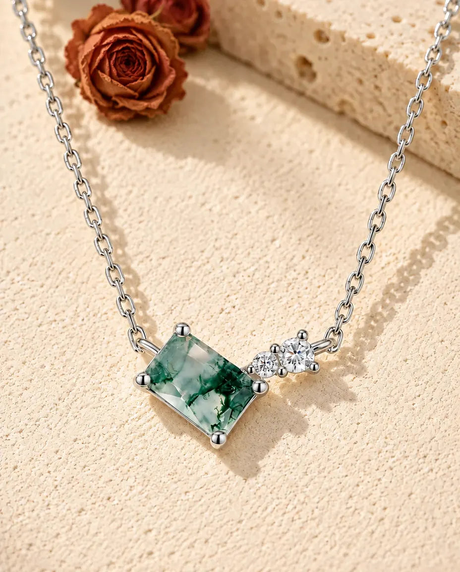 Collar de Ágata Musgosa en Plata 925 - sobre una superficie clara con textura junto a un bloque de travertino
