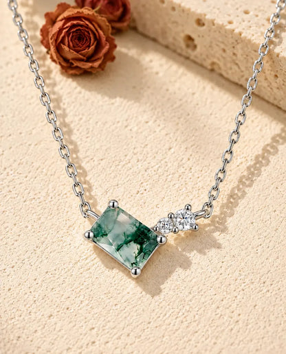 Collar de Ágata Musgosa en Plata 925 - sobre una superficie clara con textura junto a un bloque de travertino