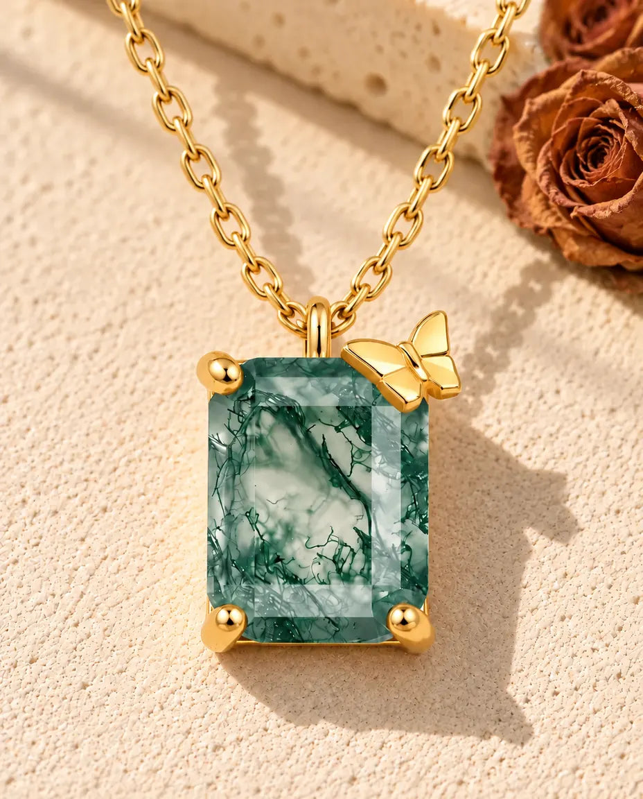 Collar de Ágata Musgosa en Plata 925 Chapada en Oro - sobre una superficie clara con textura junto a un bloque de travertino
