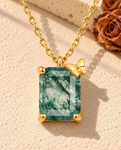 Collar de Ágata Musgosa en Plata 925 Chapada en Oro - sobre una superficie clara con textura junto a un bloque de travertino