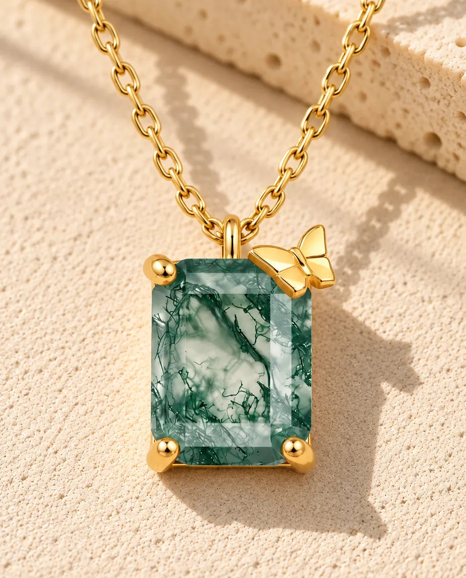 Collar de Ágata Musgosa en Plata 925 Chapada en Oro - sobre una superficie clara con textura junto a un bloque de travertino