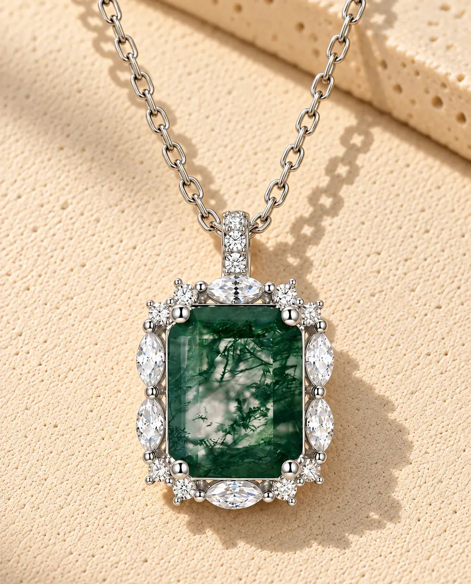 Collar de Ágata Musgosa Talla Esmeralda en Plata 925 - sobre una superficie clara con textura junto a un bloque de travertino