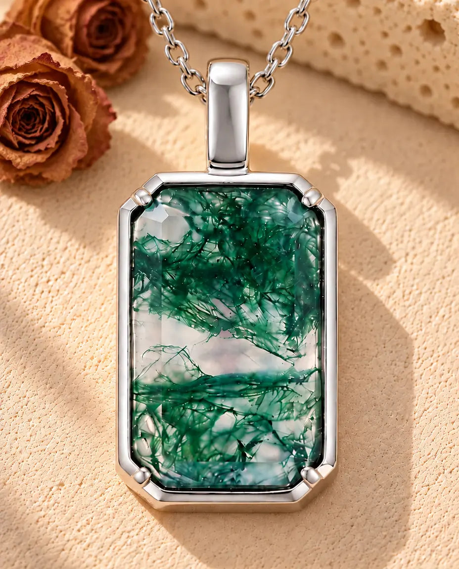 Collar de Ágata Musgosa Colgante Rectangular en Plata 925 - sobre una superficie clara con textura junto a un bloque de travertino