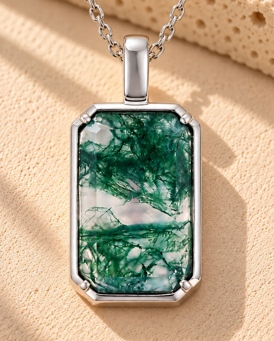 Collar de Ágata Musgosa Colgante Rectangular en Plata 925 - sobre una superficie clara con textura junto a un bloque de travertino